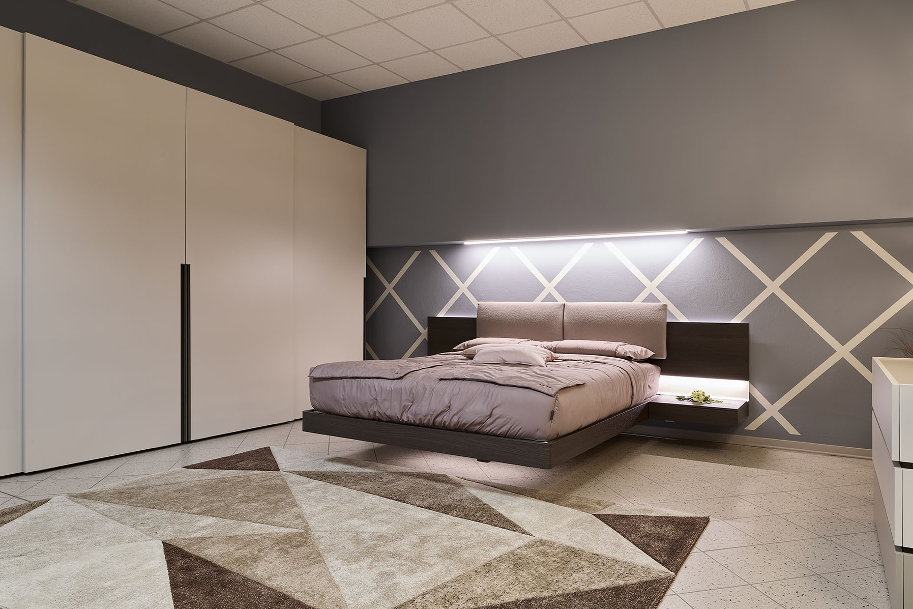 Camera da letto con letto sospeso e illuminazione lineare.