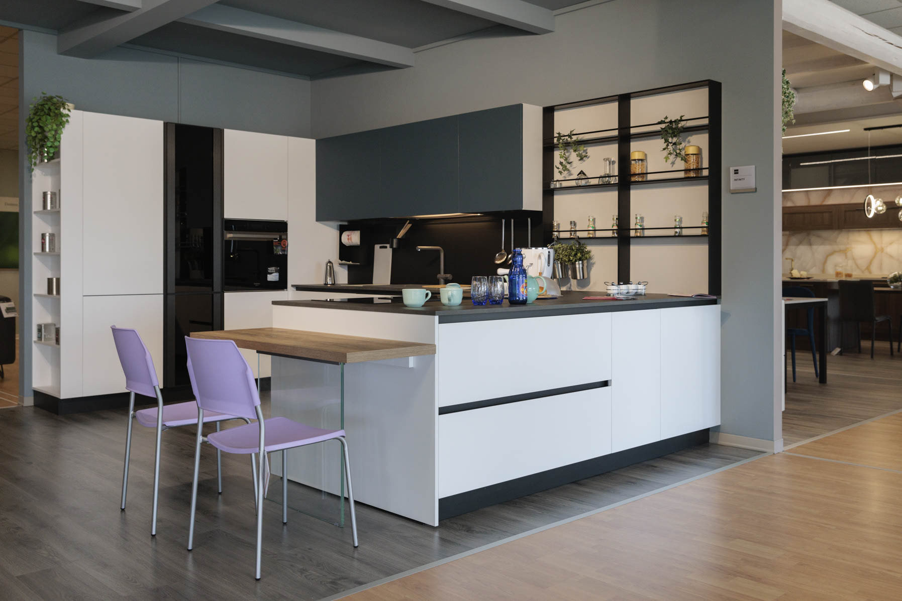 Cucina in esposizione con penisola e tavolino da pasto.