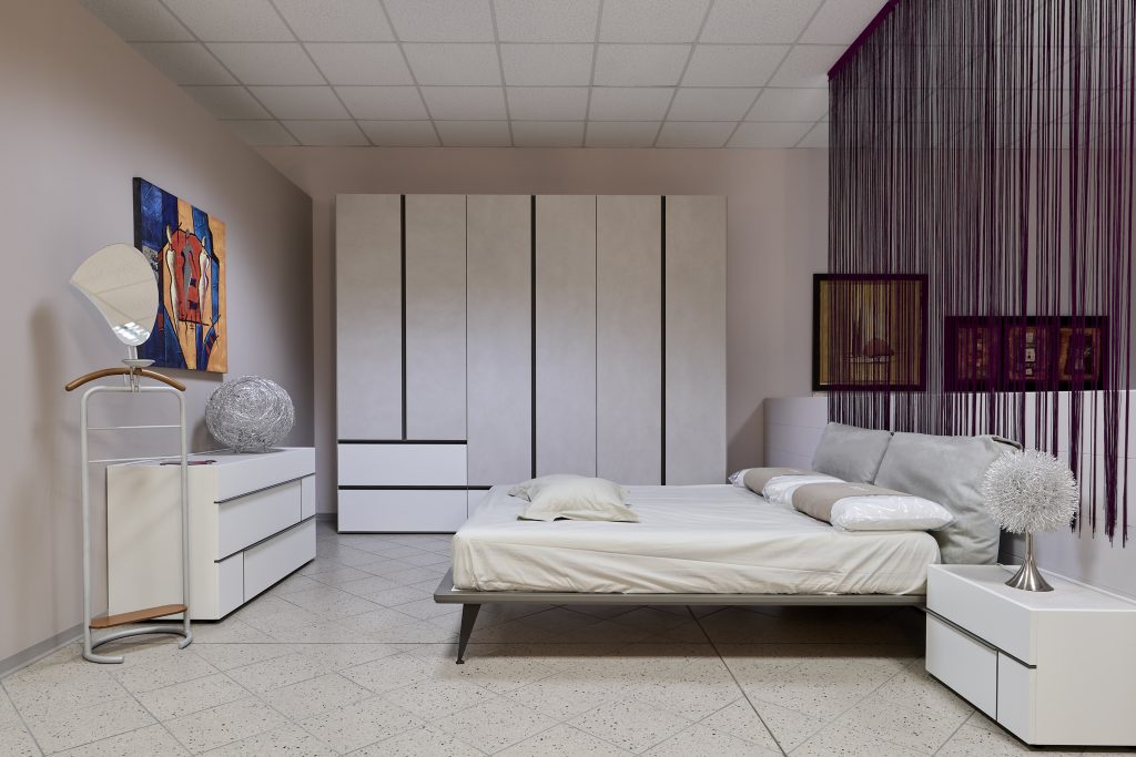 Camera da letto matrimoniale con arredamento di design in tonalità chiara.