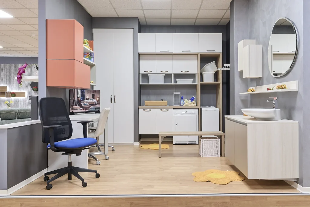 Locale di servizio arredato con lavandino, piano di appoggio e lavanderia.