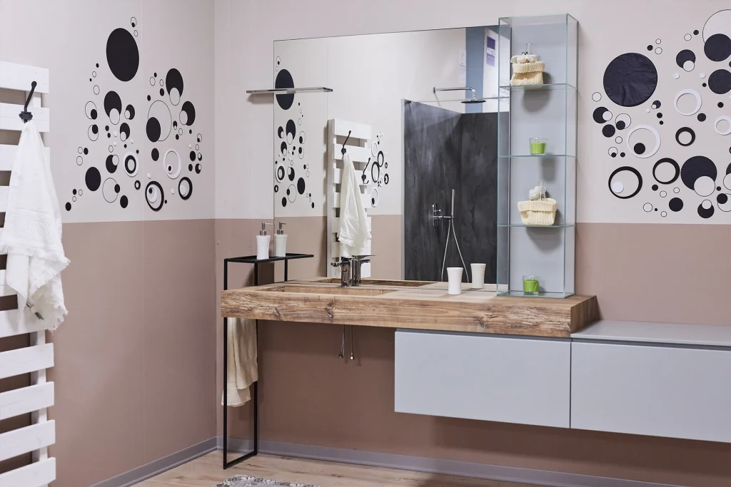 Arredo bagno, piano per lavandino in legno e decorazioni a parete circolari.